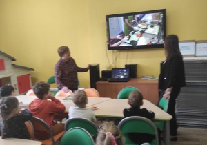 Dzieci ogladaja film o produkcji słodyczy.